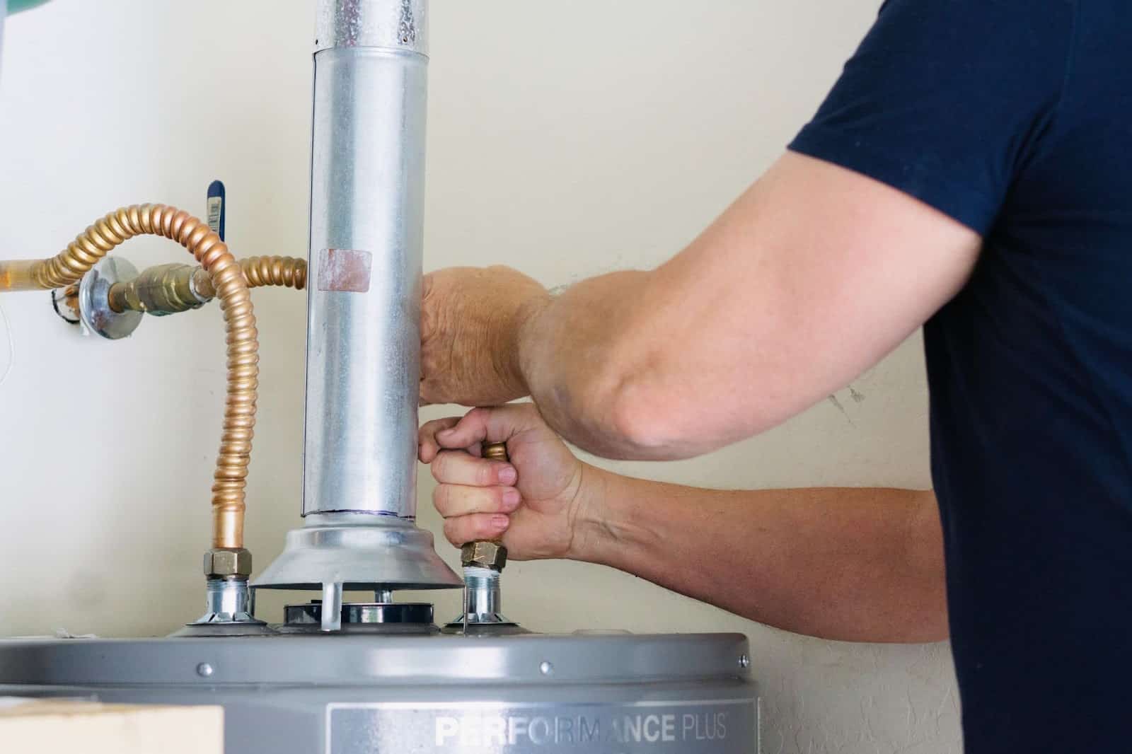 Man adjusting a water heater. 