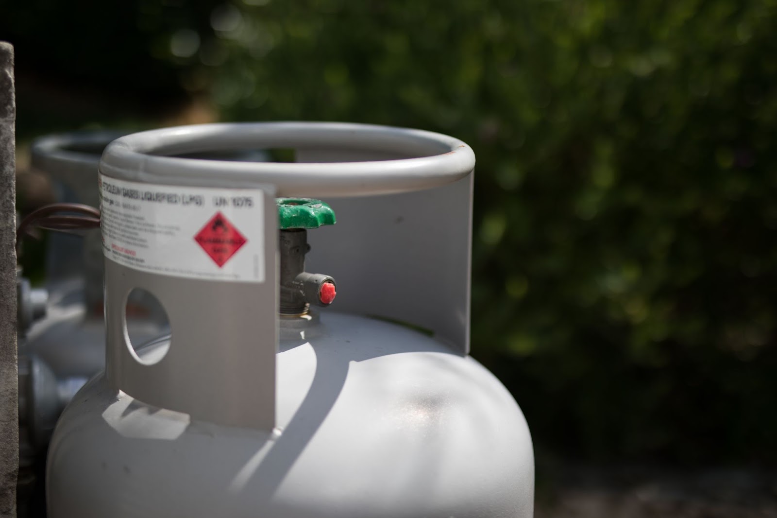 A sturdy outdoor propane gas tank stands ready for residential use.