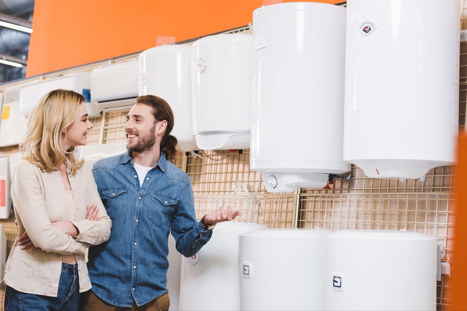 Two people looking at water heaters and boilers at a store. 